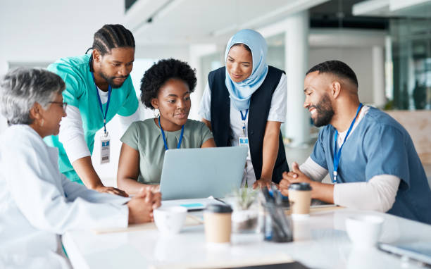 Healthcare team collaborating around a laptop