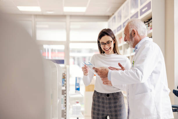 An experienced old pharmacist showing products for a baby to mother.